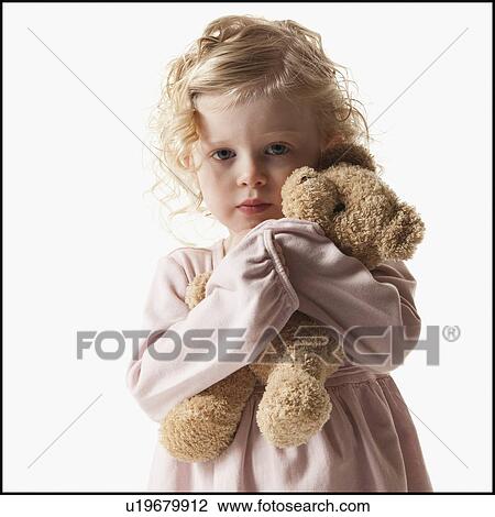 Stock Image - Young girl holding teddy bear. Fotosearch