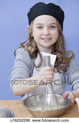 Young girl mixing with a whisk View Large Photo Image Stock Photograph - Young girl mixing with a whisk. Fotosearch