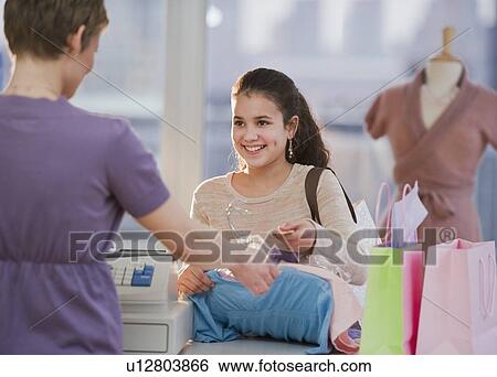 Young girl paying for clothing View Large Photo Image Stock Photograph - Young girl paying for clothing. Fotosearch