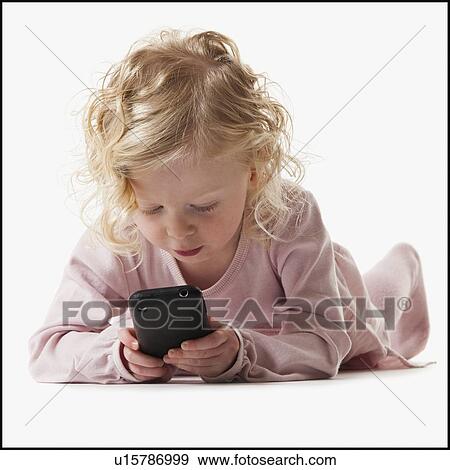 Young girl playing with a cellular phone View Large Photo Image Stock Photo - Young girl playing with a cellular phone. Fotosearch