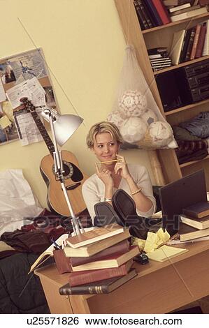 Young girl relaxing at her desk View Large Photo Image Stock Photograph - Young girl relaxing at her desk. Fotosearch