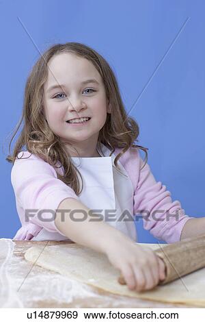 Stock Photo - Young girl rolling out bread dough. Fotosearch