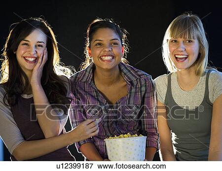 Stock Photo - Young girls eating popcorn. Fotosearch