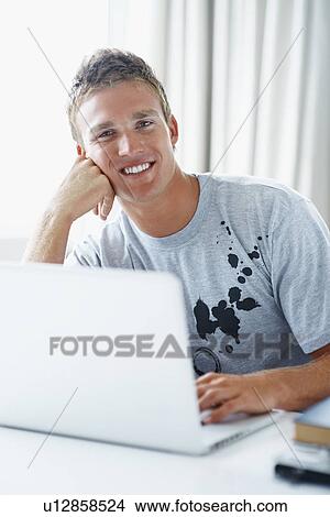 Picture - Young man working on laptop. Fotosearch