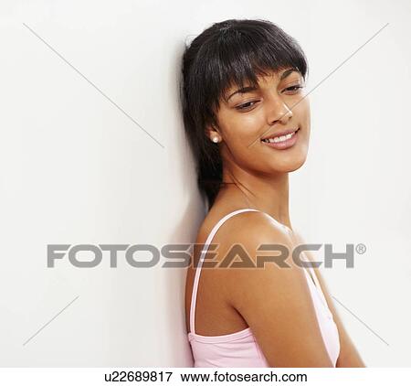 Stock Photo - Young woman leaning against wall. Fotosearch