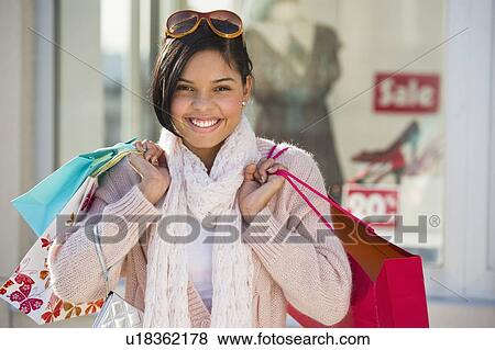 Stock Photo - Young woman with shopping bags. Fotosearch