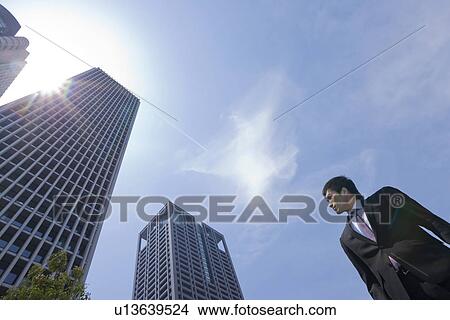 Picture - A businessman in business district. Fotosearch