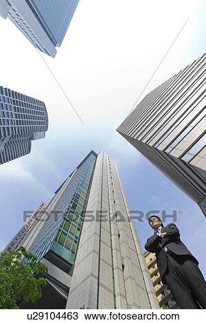 Stock Image - A businessman in business district. Fotosearch