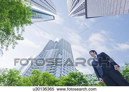 Stock Photography - A businessman in business district. Fotosearch