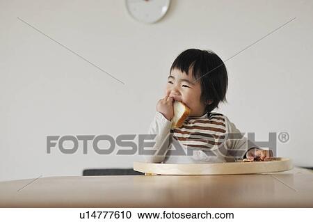 Baby boy sitting in high chair, eating bread View Large Photo Image Stock Image - Baby boy sitting in high chair, eating bread. Fotosearch