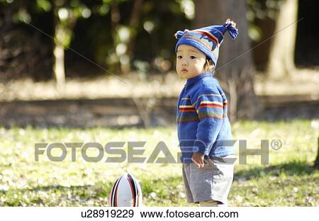 Stock Photo - Baby boy with knit hat and football, Tokyo Prefecture, Honshu, Japan. Fotosearch
