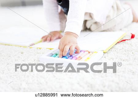Stock Image - Baby girl choosing crayons. Fotosearch