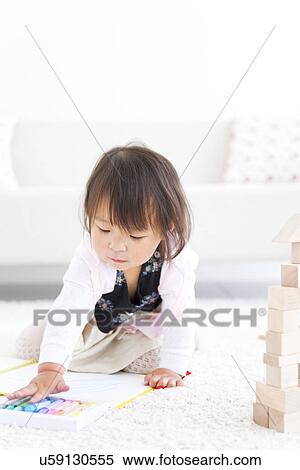 Stock Photography - Baby girl choosing crayons. Fotosearch