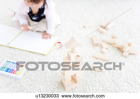 Baby girl drawing next to wooden building blocks View Large Photo Image Stock Image - Baby girl drawing next to wooden building blocks. Fotosearch