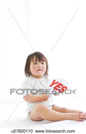 Stock Image - Baby girl holding yes sign. Fotosearch