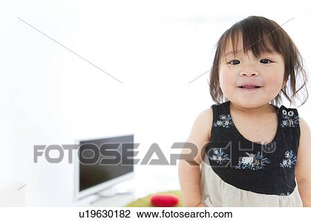 Stock Image - Baby girl looking at camera and smiling. Fotosearch
