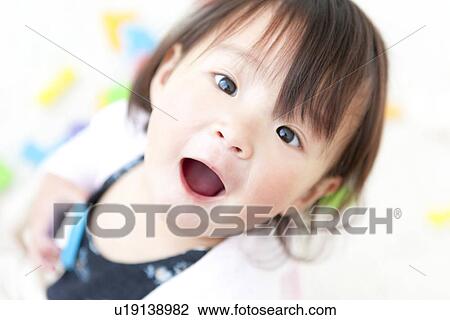 Baby girl looking at camera View Large Photo Image Stock Image - Baby girl looking at camera. Fotosearch