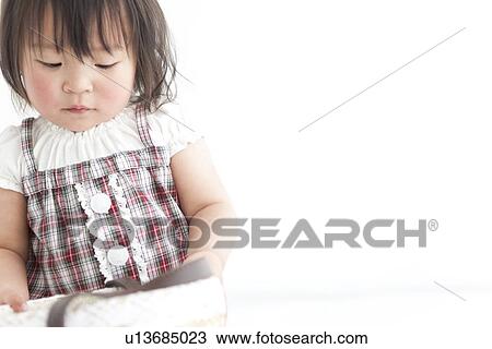 Stock Image - Baby girl looking inside the basket. Fotosearch