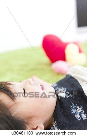 Stock Image - Baby girl lying on back. Fotosearch