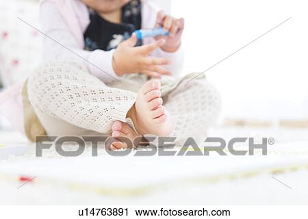 Stock Image - Baby girl playing with crayon. Fotosearch