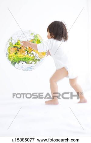 Stock Photo - Baby girl playing with globe beach ball. Fotosearch
