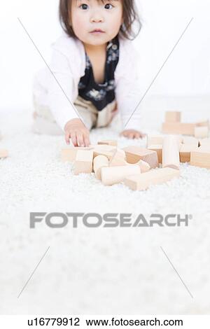 Baby girl playing with wooden building blocks View Large Photo Image Stock Image - Baby girl playing with wooden building blocks. Fotosearch