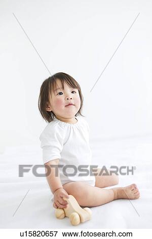 Baby girl playing with wooden toy car View Large Photo Image Stock Photo - Baby girl playing with wooden toy car. Fotosearch