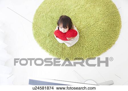 Baby girl sitting in front of TV hugging cushion View Large Photo Image Picture - Baby girl sitting in front of TV hugging cushion. Fotosearch