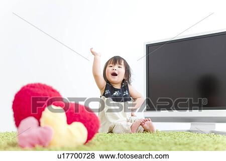 Baby girl sitting in front of TV View Large Photo Image Stock Photo - Baby girl sitting in front of TV. Fotosearch