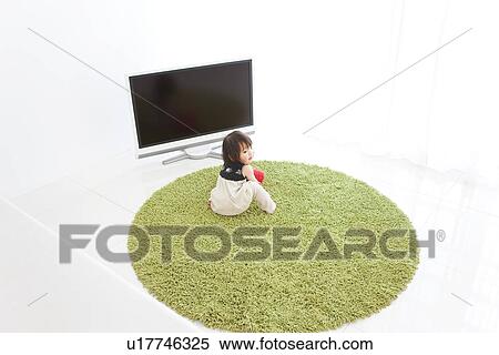 Stock Photography - Baby girl sitting on rug. Fotosearch