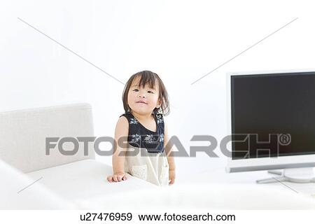 Baby girl standing next to sofa View Large Photo Image Stock Photo - Baby girl standing next to sofa. Fotosearch