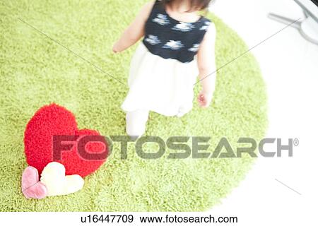 Stock Photo - Baby girl walking on rug, high angle view. Fotosearch