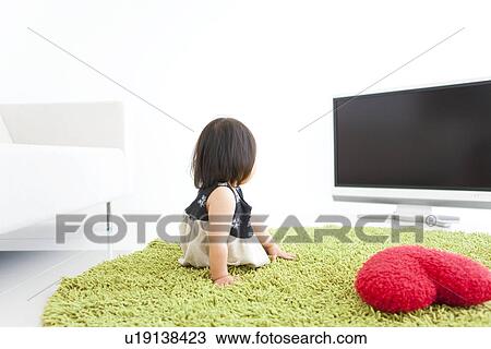 Baby girl watching television View Large Photo Image Stock Image - Baby girl watching television. Fotosearch
