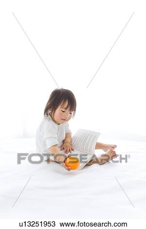 Baby girl with book and orange View Large Photo Image Stock Image - Baby girl with book and orange. Fotosearch