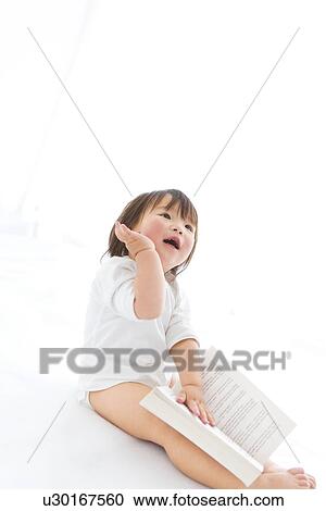 Baby girl with open book and hand raised View Large Photo Image Stock Image - Baby girl with open book and hand raised. Fotosearch