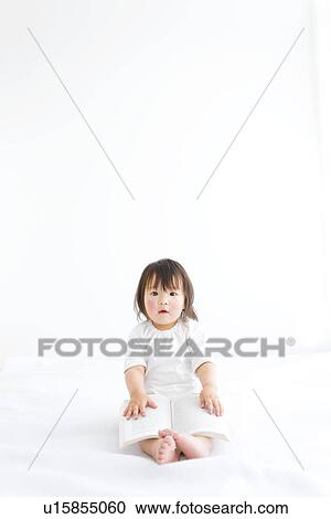 Stock Image - Baby girl with open book. Fotosearch