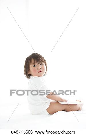 Stock Image - Baby girl with open book. Fotosearch