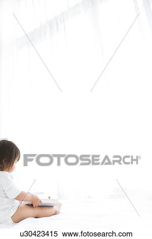 Stock Photography - Baby girl with open book. Fotosearch