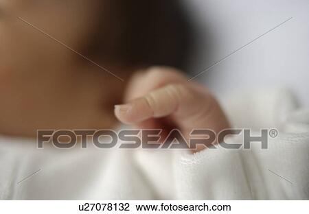 Stock Image - Baby lying on bed, close up, differential focus. Fotosearch