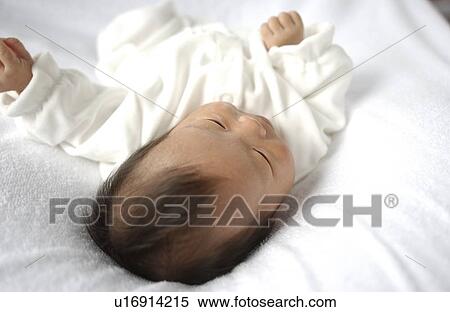Stock Photography - Baby lying on bed, close up. Fotosearch