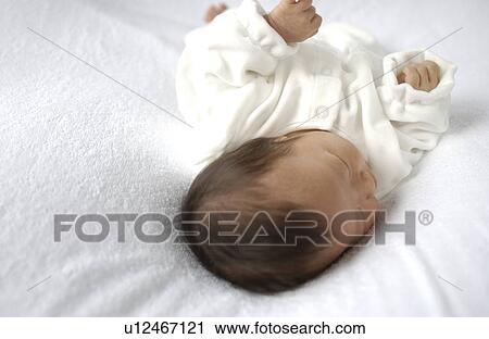 Baby lying on bed View Large Photo Image Stock Image - Baby lying on bed. Fotosearch