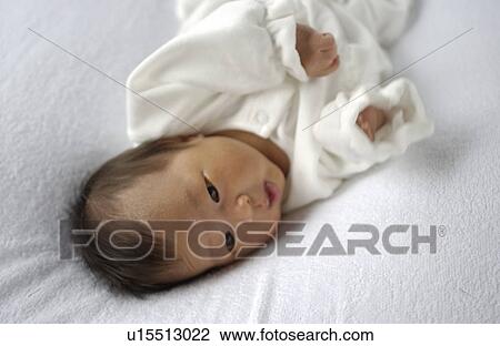 Stock Image - Baby lying on bed. Fotosearch