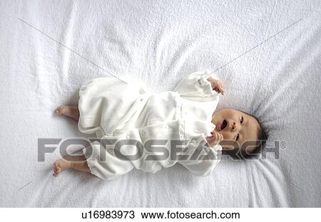 Baby lying on bed View Large Photo Image Stock Image - Baby lying on bed. Fotosearch