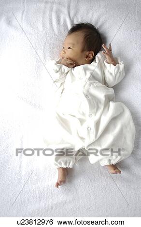 Baby lying on bed View Large Photo Image Stock Photograph - Baby lying on bed. Fotosearch