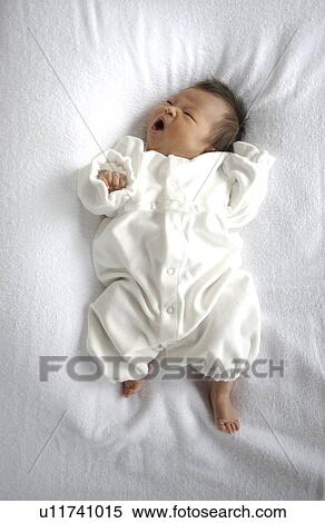 Stock Photography - Baby lying on bed. Fotosearch