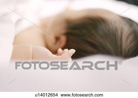 Picture - Baby sleeping on bed, close up, differential focus. Fotosearch