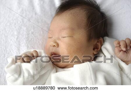 Stock Image - Baby sleeping on bed, close up. Fotosearch
