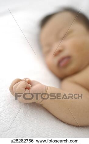 Stock Photograph - Baby sleeping on bed, differential focus. Fotosearch