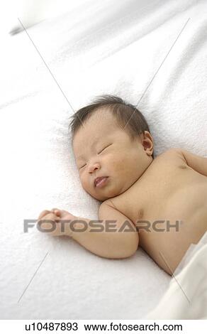 Stock Image - Baby sleeping on bed. Fotosearch