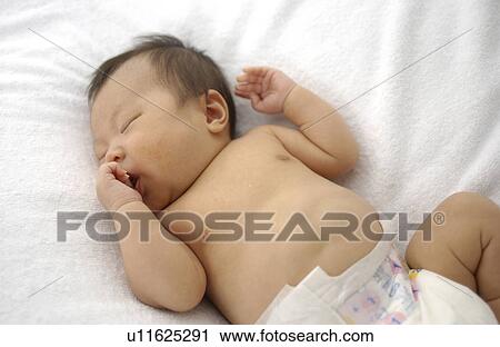 Stock Image - Baby sleeping on bed. Fotosearch